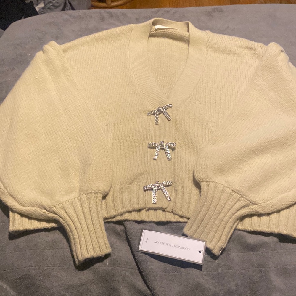 Tan sweater with silver bows. Perfect condition. Never worn. Tag attached